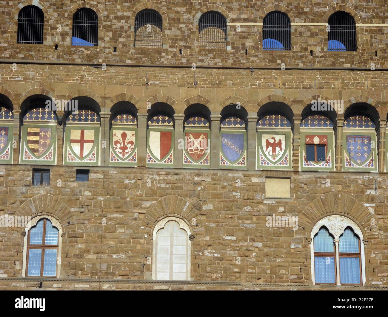 Detail aus dem Palazzo Vecchio. Rathaus von Florenz, Italien. Eine große romanische Festung - Palast mit Blick auf den Piazza della Signoria. Von dem Architekten Arnolfo di Cambio in 1299 konzipiert. Dieses Bild zeigt die Bögen in der Struktur, die mit den 9 Wappen der Florentinischen Republik eingerichtet sind. Stockfoto