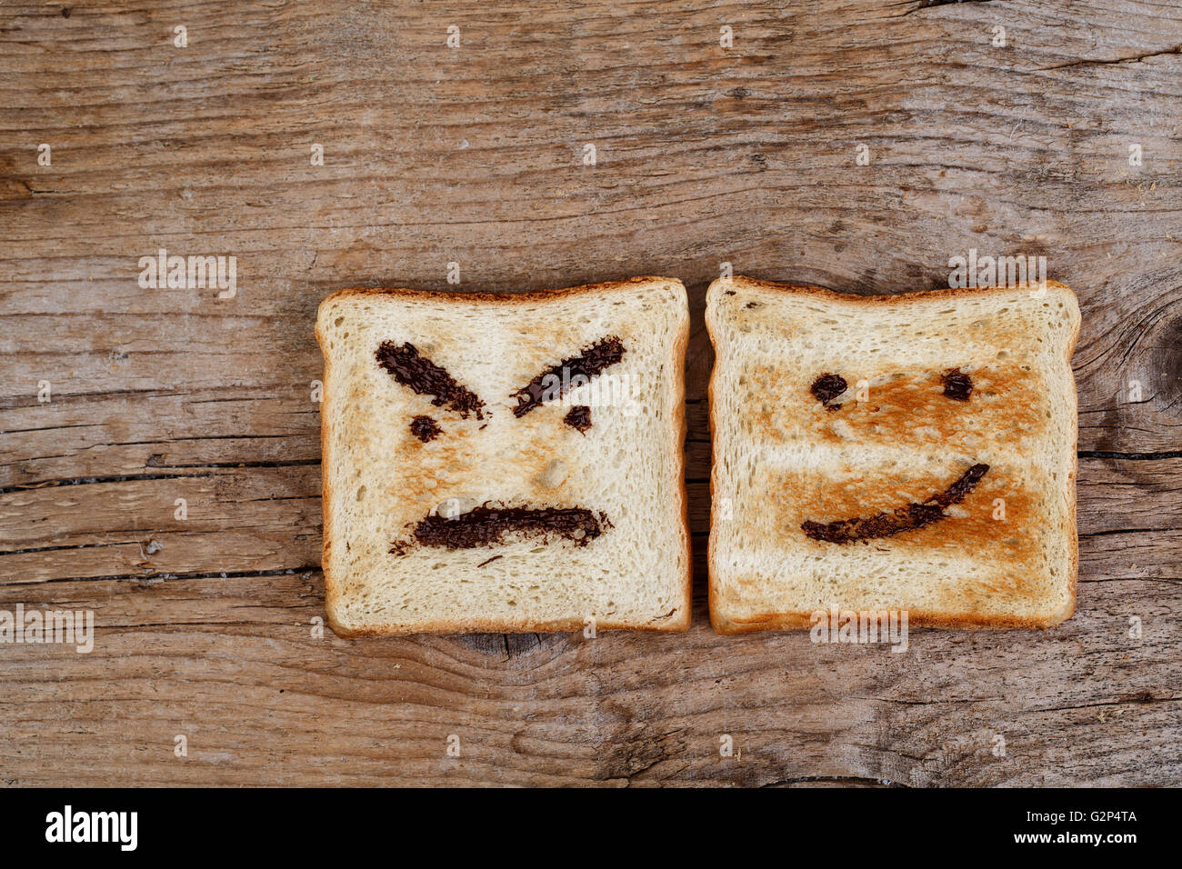 Toastbrot mit glücklich und böse Gesicht gemalt mit Haselnuss Schokolade Verbreitung Stockfoto