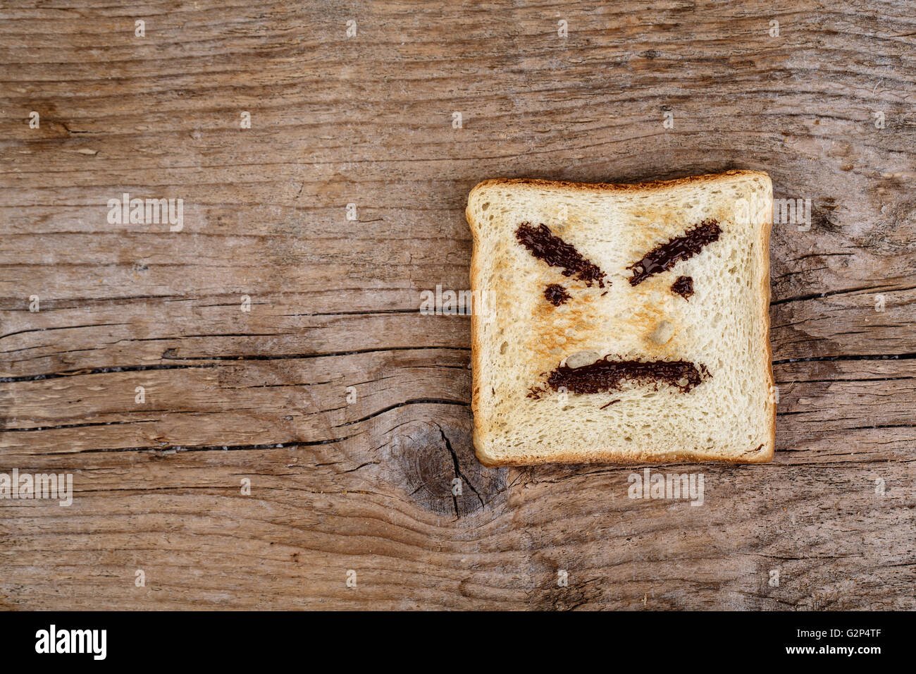 Toastbrot mit wütendes Gesicht gemalt mit Haselnuss Schokolade Verbreitung Stockfoto