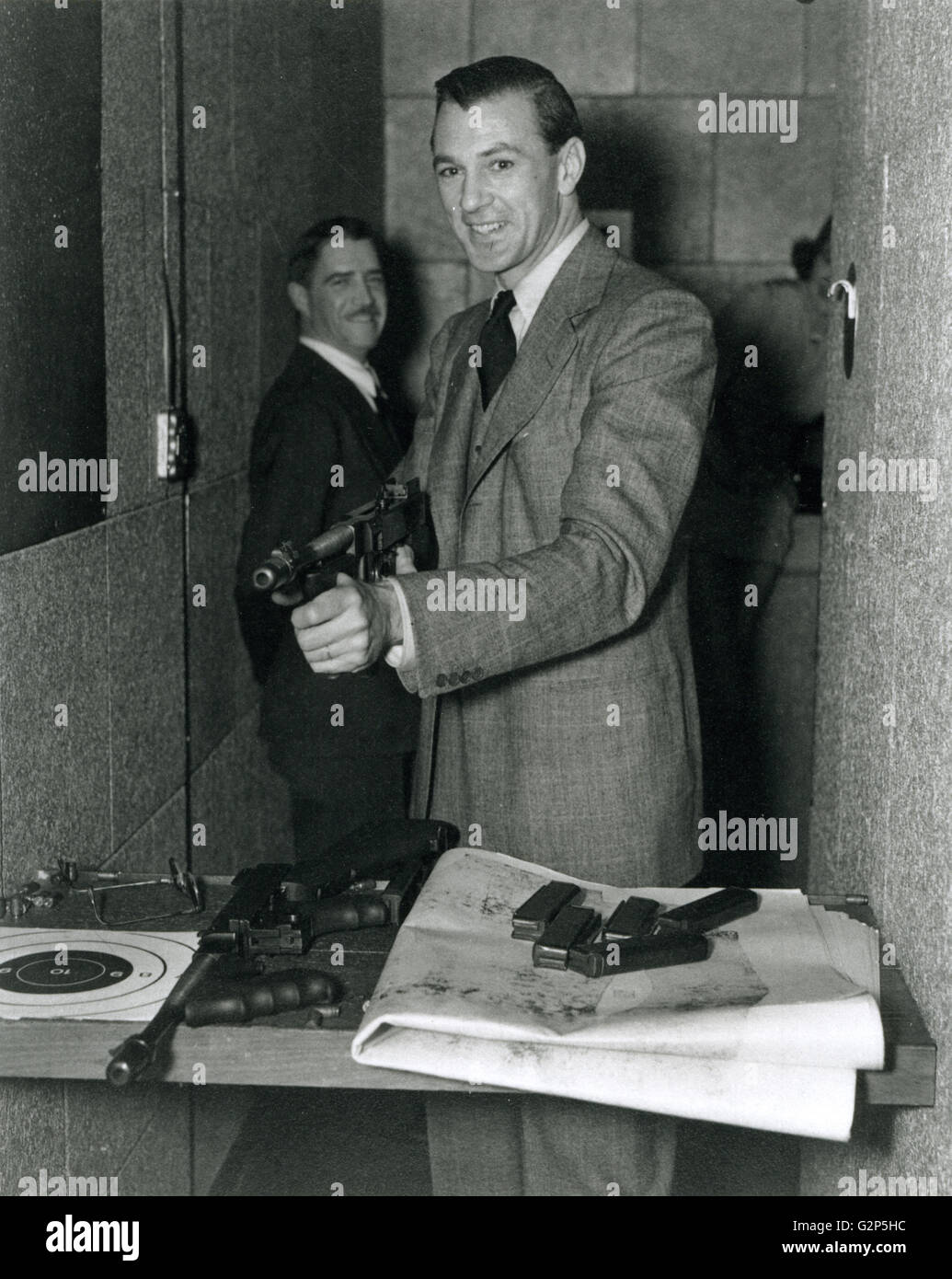 Schauspieler Gary Cooper mit einer Thompson Maschinenpistole auf dem Schießplatz FBI. Stockfoto