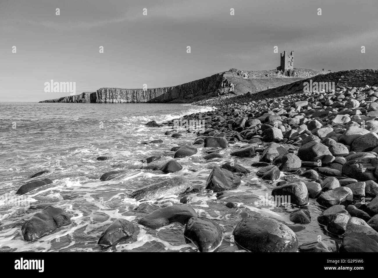 Dunstanburgh Castle in Monochrom, an der nordöstlichen Küste von Northumberland, England, UK Stockfoto