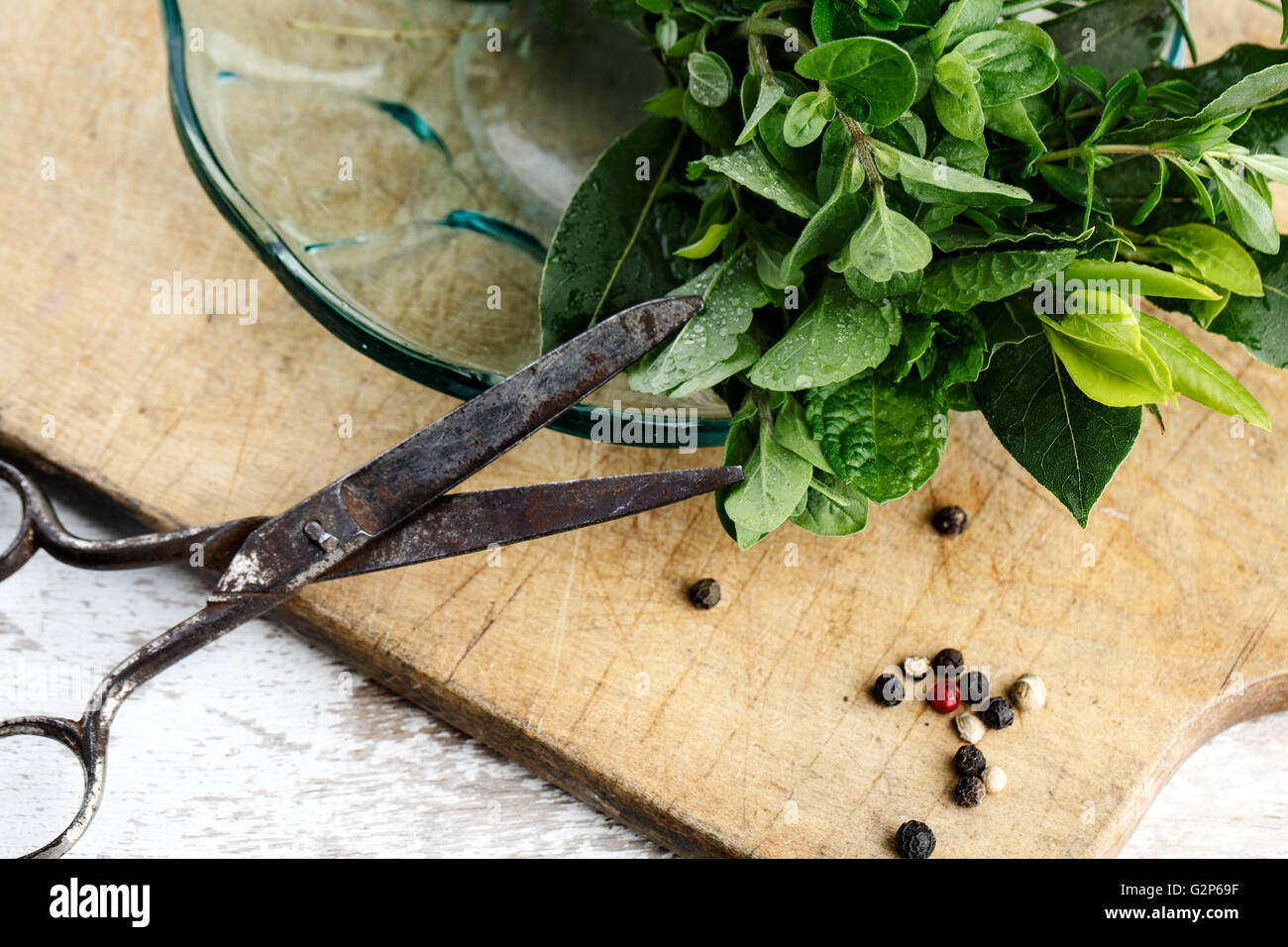 Thymian, Salbei und Rosmarin mit Lorbeer gebündelt mit Baumwolle String und alten rostigen Schere auf Holzbrett Stockfoto