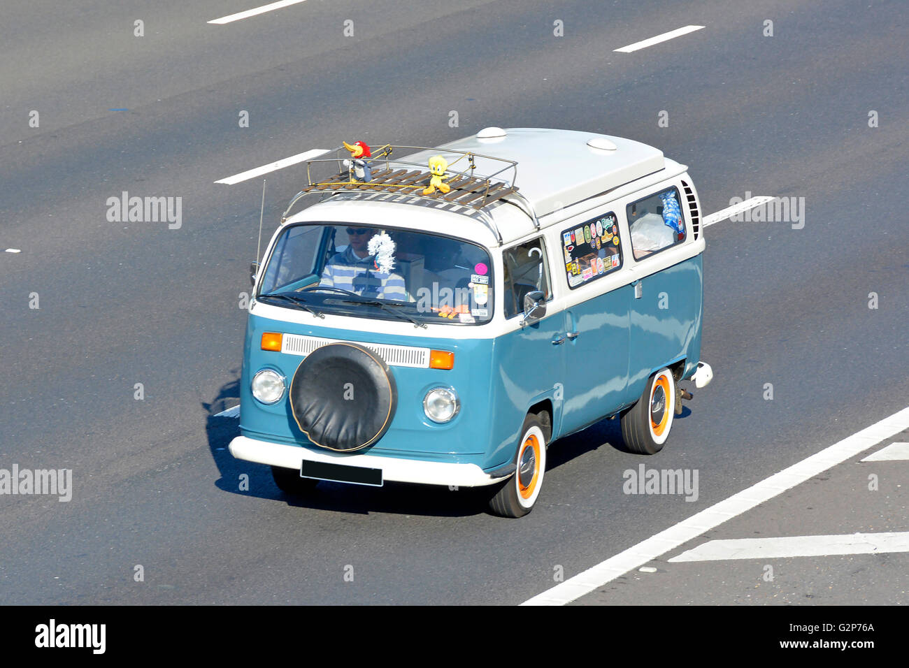 Luftaufnahme von der Seite und von vorne mit Blick auf den klassischen VW Volkswagen Camper van fahren entlang englischer UK Autobahn verdeckt Nummer Platte Stockfoto