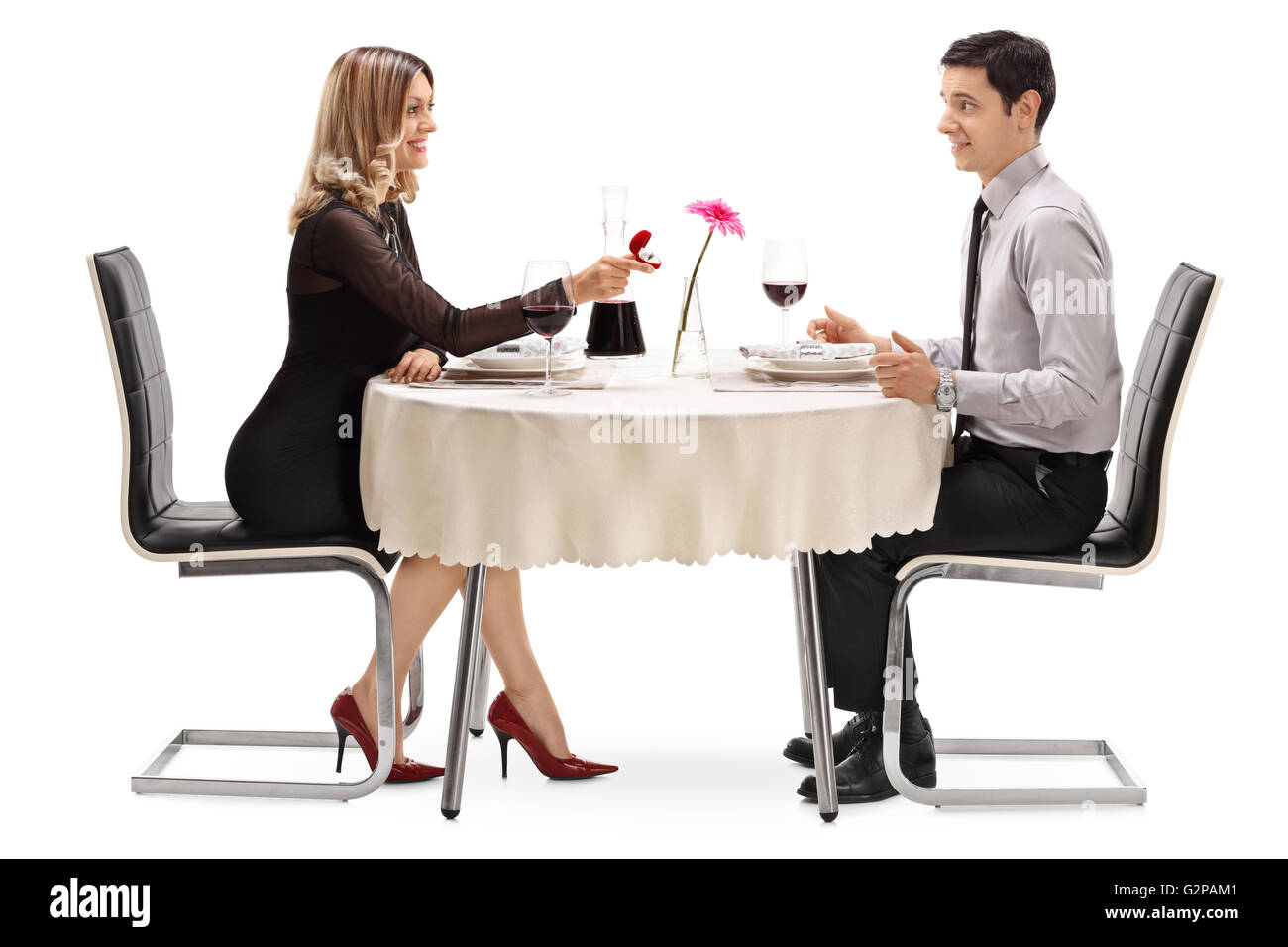 Junge Frau zu ihrem Freund auf einem Tisch im Restaurant isoliert auf weißem Hintergrund Stockfoto