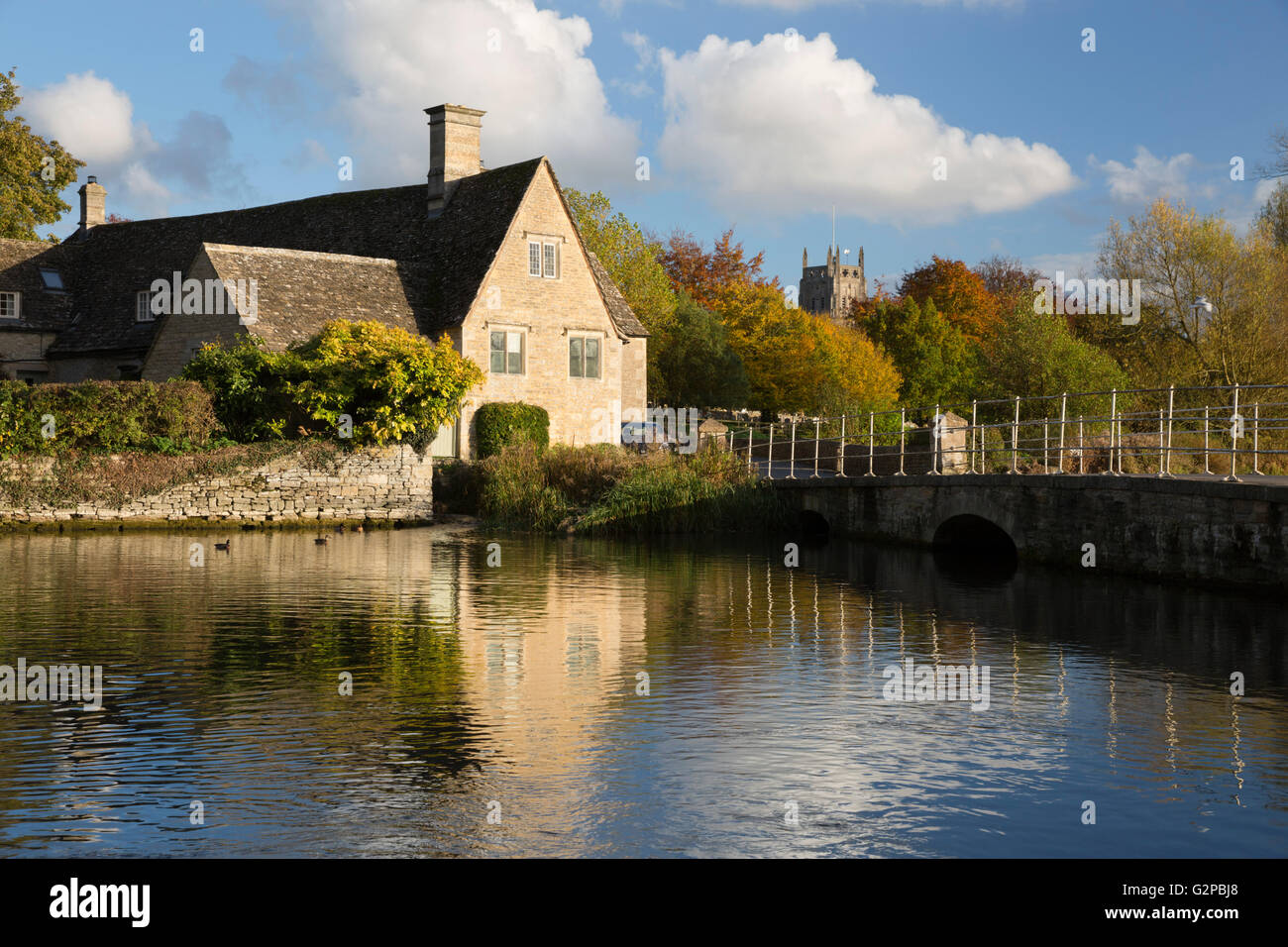 Haus und Kirche auf dem Fluss Coln im Herbst, Fairford, Cotswolds, Gloucestershire, England, Vereinigtes Königreich, Europa Stockfoto