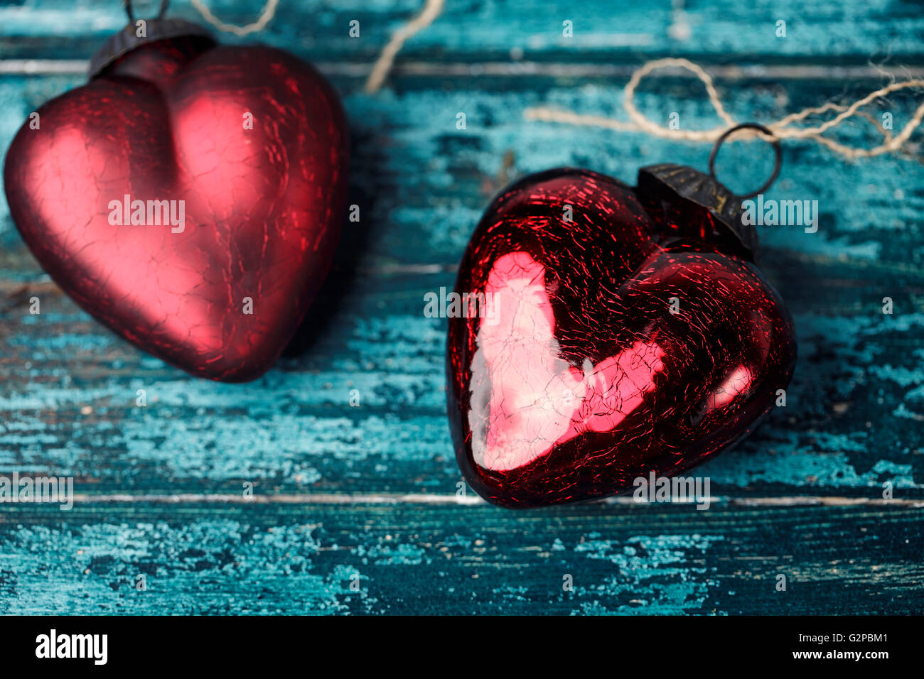 Hell karminroten roten Herzen auf Cyan farbige Holzbrett Stockfoto