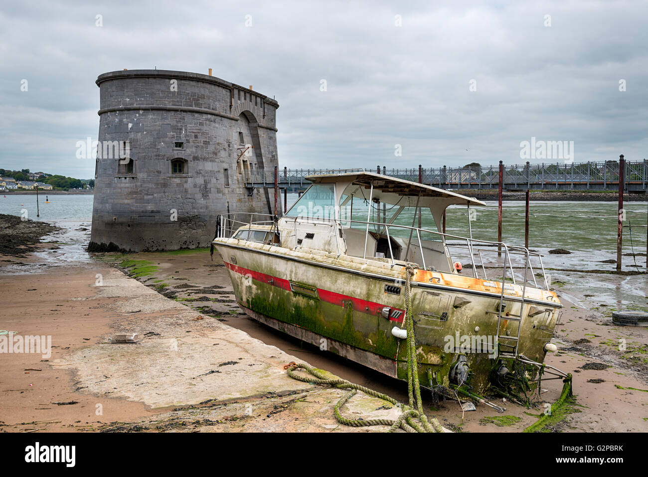 Ein Alter Martello-Turm und eine gewaschene, Boot am Pembroke Dock an der Küste von Pembrokeshire in Wales Stockfoto