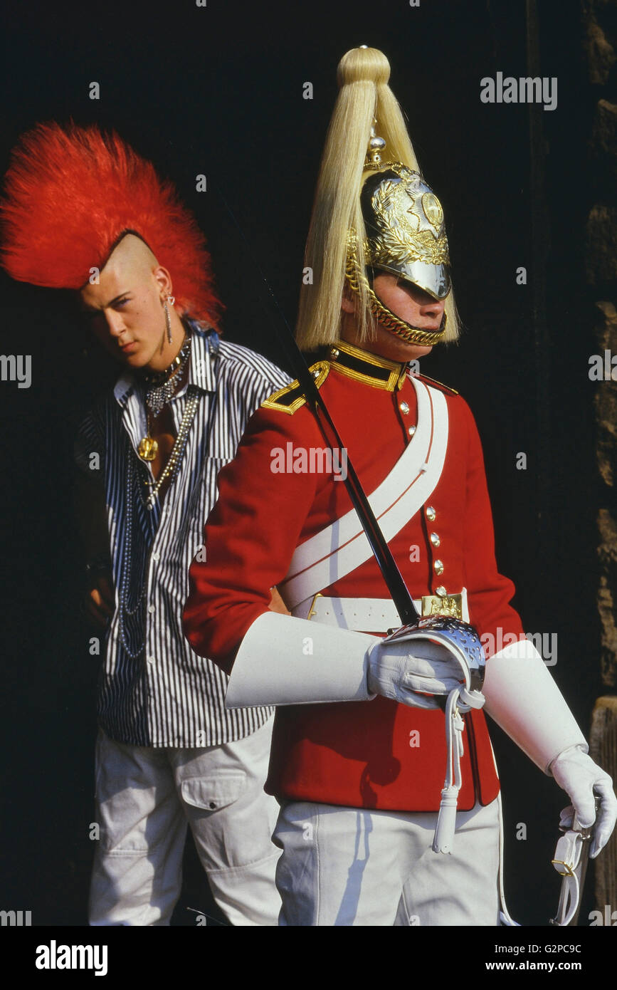 Punk Rocker Matt Belgrano, "der Herr Punk' steht mit einem Mitglied der Household Cavalry, Horse Guards Parade, London, England, UK, ca. 1980 Stockfoto