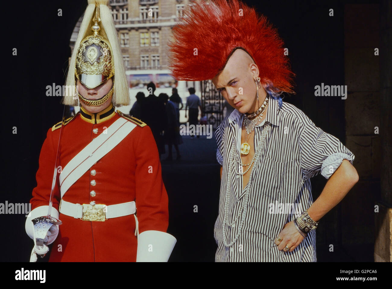 Punk Rocker Matt Belgrano, "der Herr Punk' steht mit einem Mitglied der Household Cavalry, Horse Guards Parade, London, England, UK, ca. 1980 Stockfoto