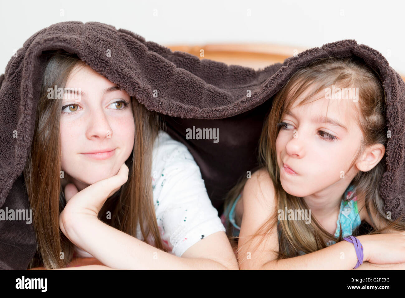 Porträt von zwei Schwestern mit einer Decke bedeckt Stockfoto