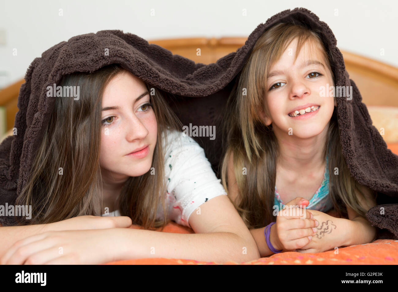 Porträt von zwei Schwestern mit einer Decke bedeckt Stockfoto