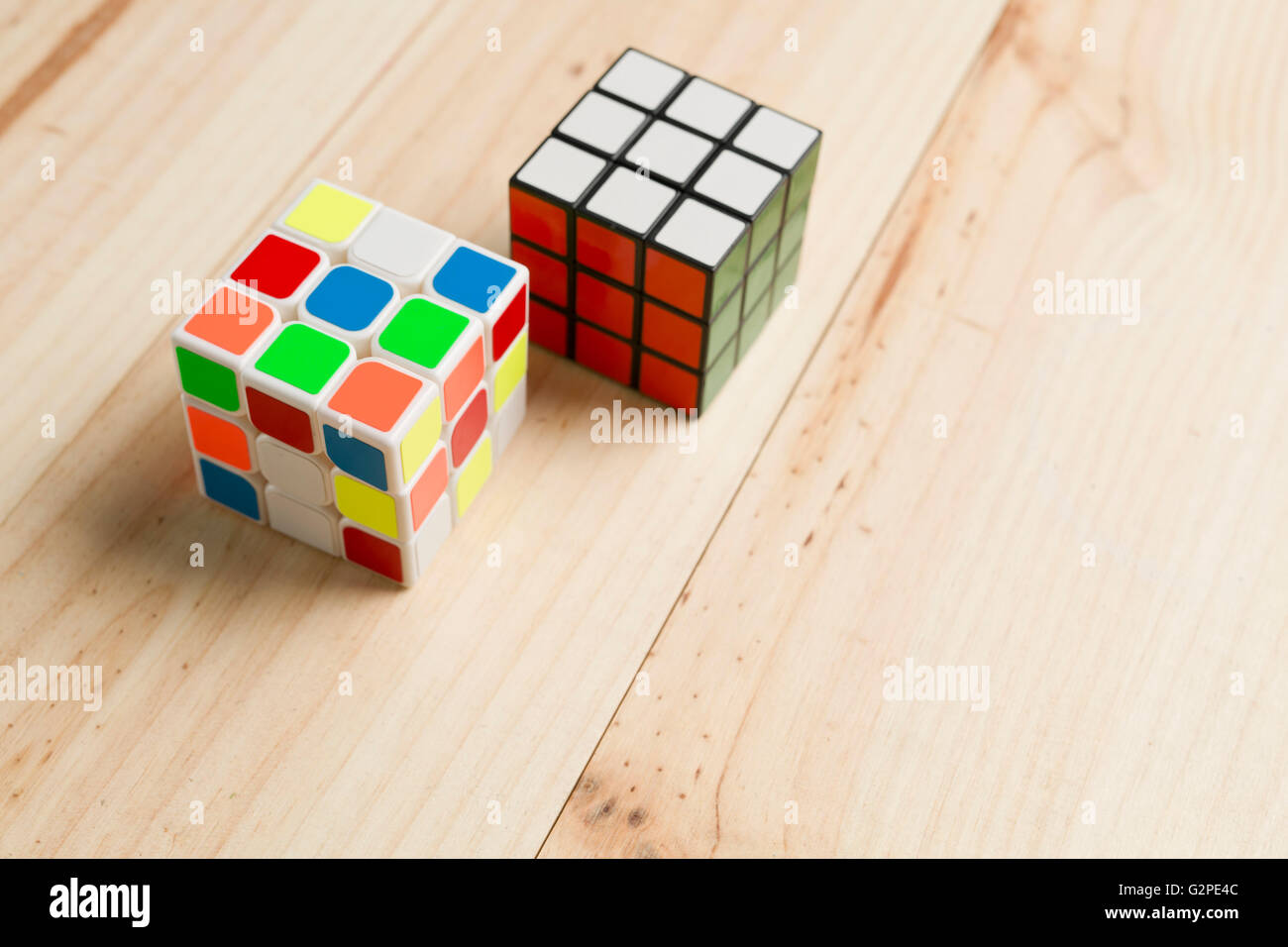 Elche, Spanien. 26. Mai 2016: Zwei Rubik-Würfel auf einem Hintergrund von Kiefernholz. Stockfoto
