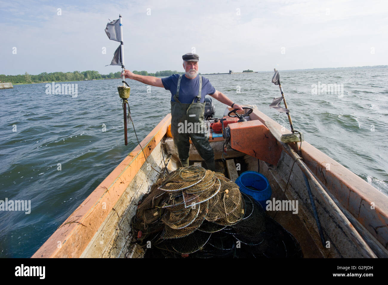 Rügen, Deutschland. 31. Mai 2016. Juergen Krieger steht auf seine Angeln Boot Seestern DRA.004 Angeln auf Aale im Rassower Strom in Dranske auf der Insel Rügen, Deutschland, 31. Mai 2016. Am Ende des Jahres wird er die letzten Fischer in Altdorf Dranske in den Ruhestand. Nachfolger für hartes Stück Arbeit, gibt es wenig. In den 1970er Jahren engagierte Krieger Hochseefischen. In der Barentssee und an den Küsten vor Mosambik fuhren die Trawler Fabrikschiffe der DDR-Hochseefischerei-Flotte. Die Warrio war 120 Tage pro Jahr auf See. Foto: Stefan Sauer/Dpa/Alamy Live News Stockfoto