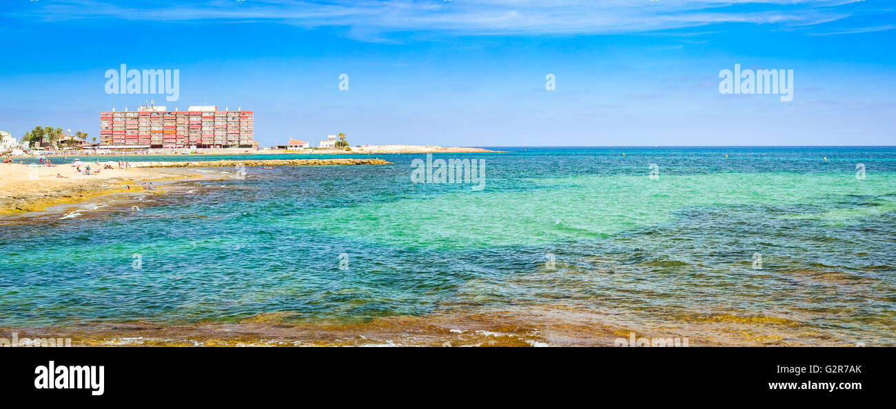 TORREVIEJA, Spanien - 13. September 2014: Sonnige Mittelmeer Strand, Touristen auf warmen Sand auf Liegestühlen unter Sonnenschirmen entspannen Stockfoto