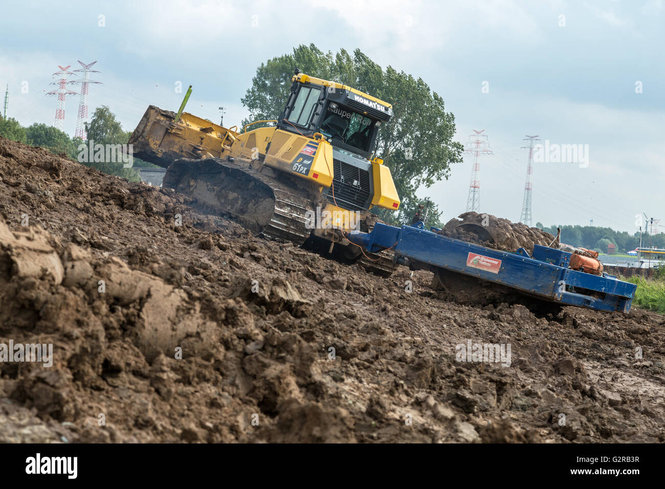22.09.2015, Bremen, Bremen, Deutschland - Deicherhoehung an der Weser durch Anstieg des Meeresspiegels. Bulldozer Schaufel und richtete mit durch Gewicht, das neue Kernprofil des erhöhten Deiches verdichtet. Durchgeführt im Rahmen des Masterplans Kuestenschutz Niedersachsen / Bremen, die besagt, dass das Land schützende Deich von 7,70 m auf 8, 70 m erhöht wird. Diese geplante Stufe gilt für die gesamte Nordsee-Küste, Version bis zum Jahr 2025. Verantwortlich für Bremen Bremische Deichverband. / Aufstockung des Deiches an der Weser durch den Anstieg des Meeresspiegels an der Küste der Nordsee. 00A1 Stockfoto