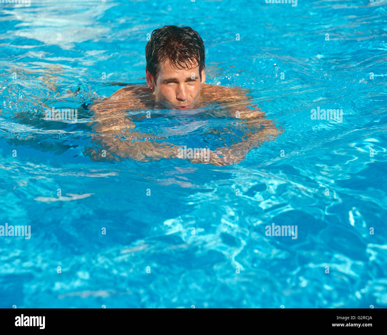 Ein Kerl in einem Pool schwimmen. Stockfoto
