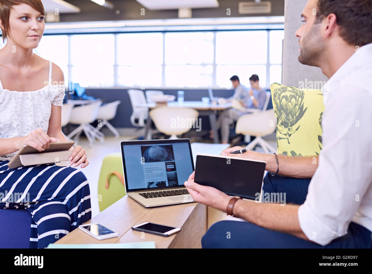 Frau Holding Tablet unter Beachtung männliche Geschäftspartner Stockfoto