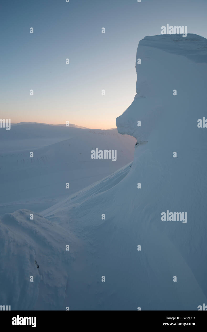 Winterliche Lichtverhältnisse und Wildnis in der arktischen Landschaft von Svalbard bei Trollsteinen. Schnee lässt Felsen wie ein Gesicht aussehen.Spitzbergen, Spitzbergen, Norwegen Stockfoto