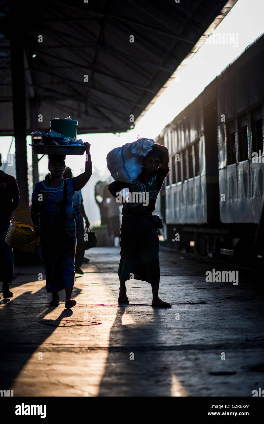 Silhouette von Personen mit Gepäck wartet auf die Abfahrt des Zuges an der Yangon Central Train Station, Myanmar. Stockfoto