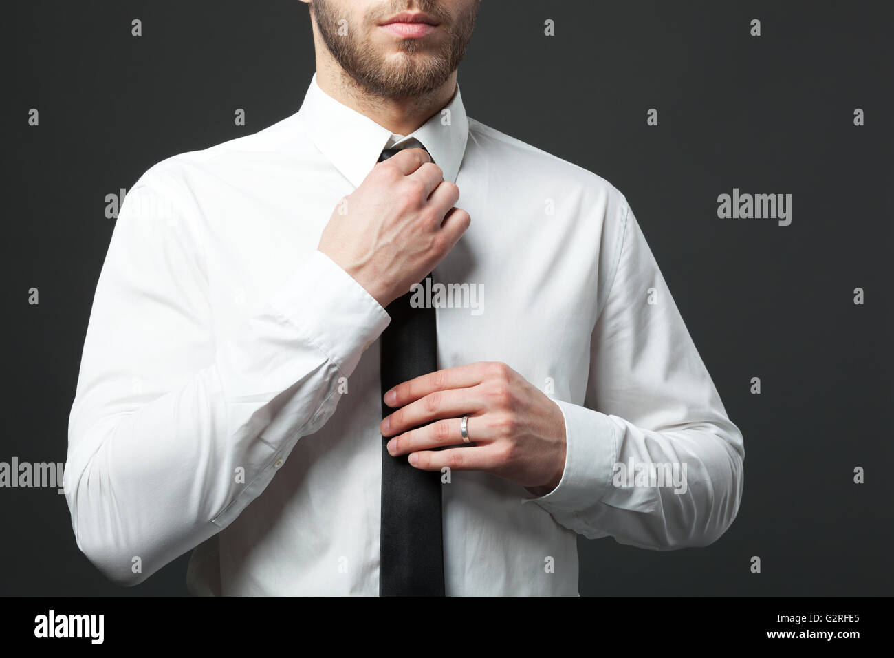 Innenfeldes jungen Fit Geschäftsmann Krawatte isoliert auf dunklem Hintergrund anpassen. Stockfoto