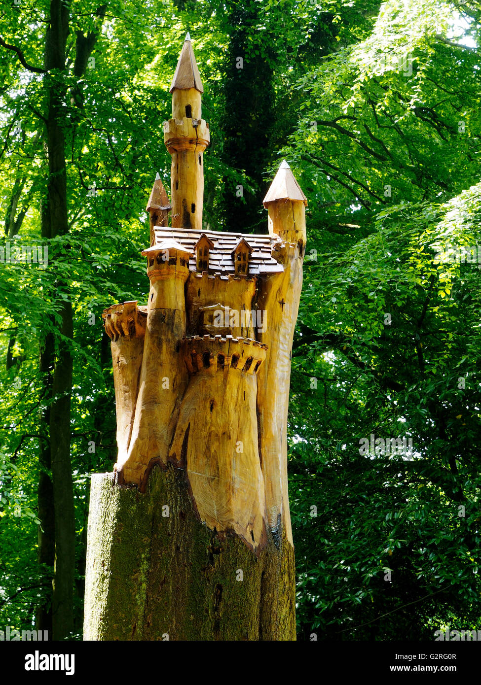 Eine Märchenschloss Kettensäge aus dem Baumstumpf im Wald Schneeglöckchen Grove in Painswick Rokoko Gasrden geschnitzt. Stockfoto