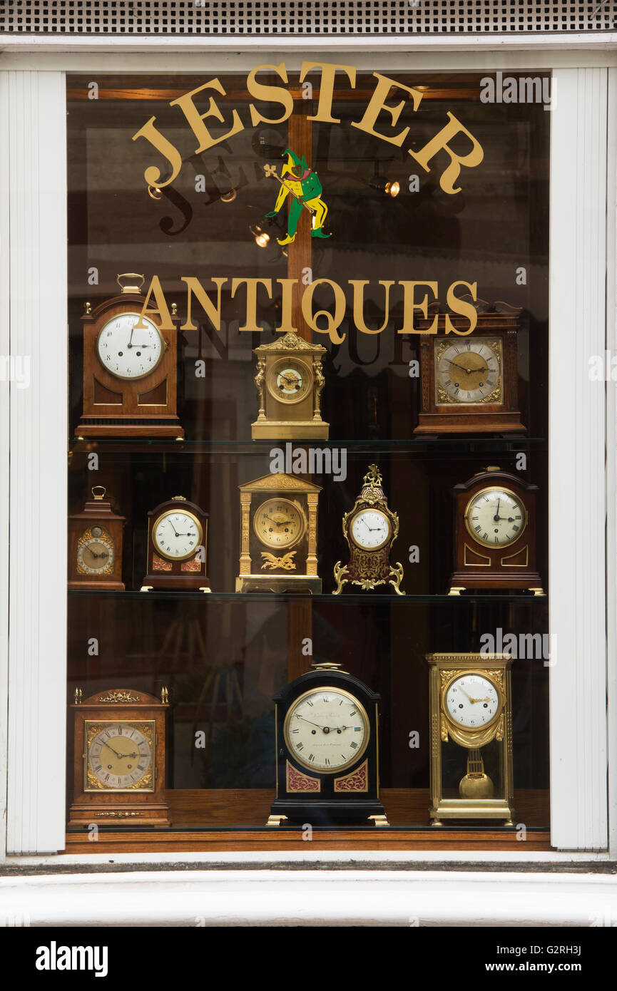 Antike Uhren in einem Tetbury Antiquitätengeschäft Fenster. Tetbury, Gloucestershire, England Stockfoto