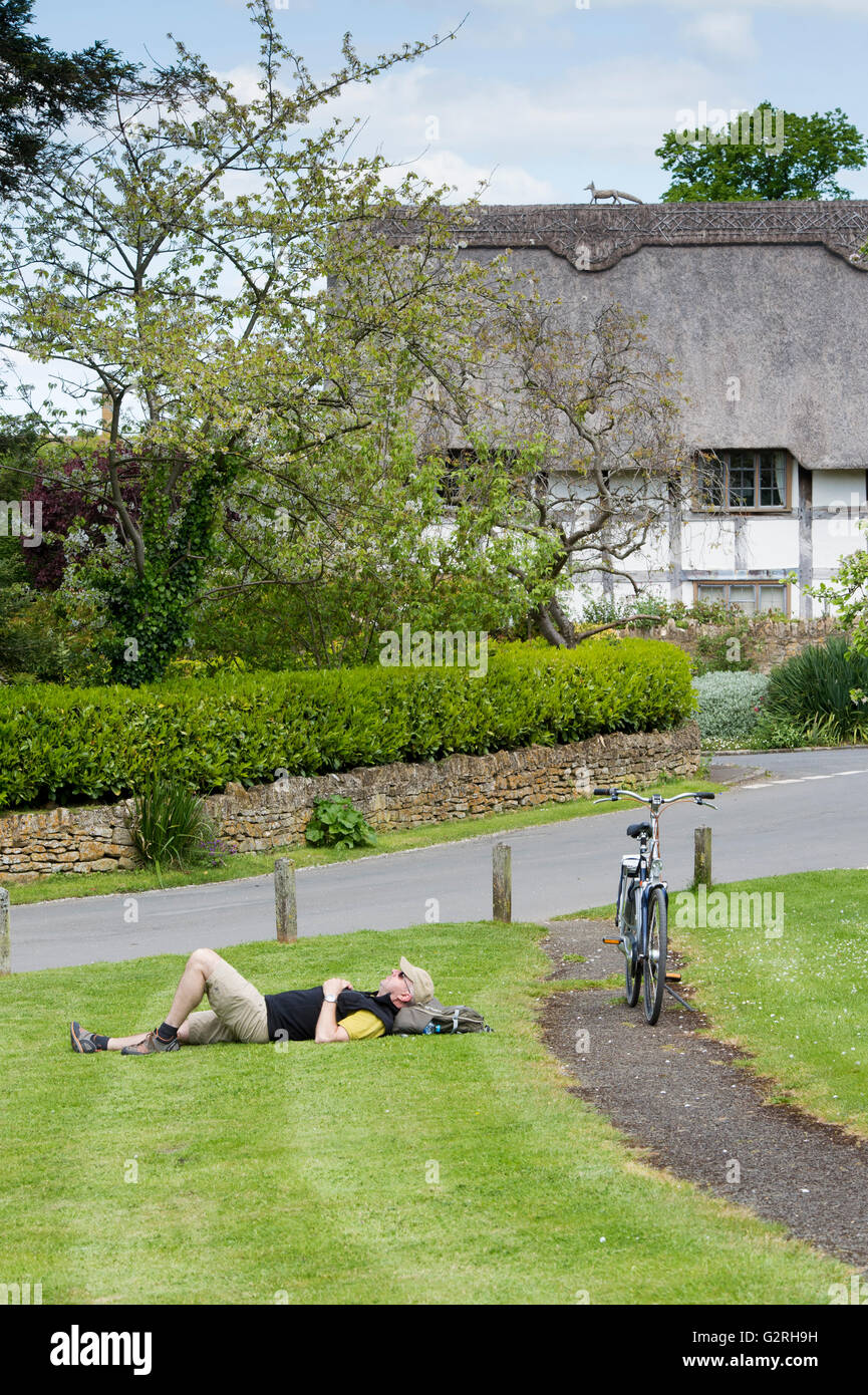 Radfahrer auf Rasen in Te Cotswold Dorf von Stanton. Cotswolds, Gloucestershire, England Stockfoto
