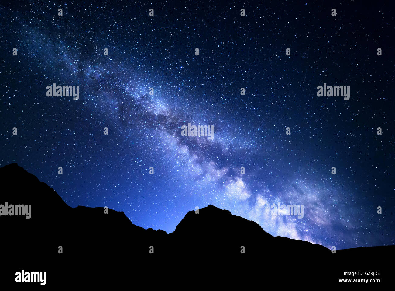 Nacht Landschaft mit bunten Milchstraße und blaues Licht zu Bergen. Sternenhimmel mit Felsen am Sommer. Schöne Universum Stockfoto