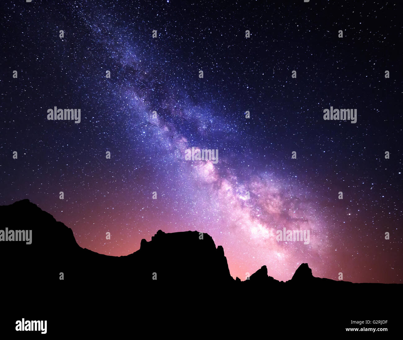 Nacht Landschaft mit bunten Milchstraße und gelbe Licht am Berge. Sternenhimmel mit Felsen am Sommer. Schöne Universum Stockfoto