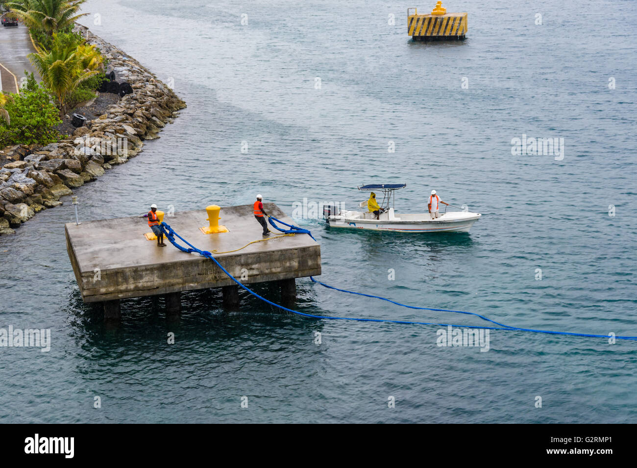 Arbeiter bereiten gerne ein Kreuzfahrtschiff Andocken am Hafen von Roatan, Roatan, Honduras Stockfoto