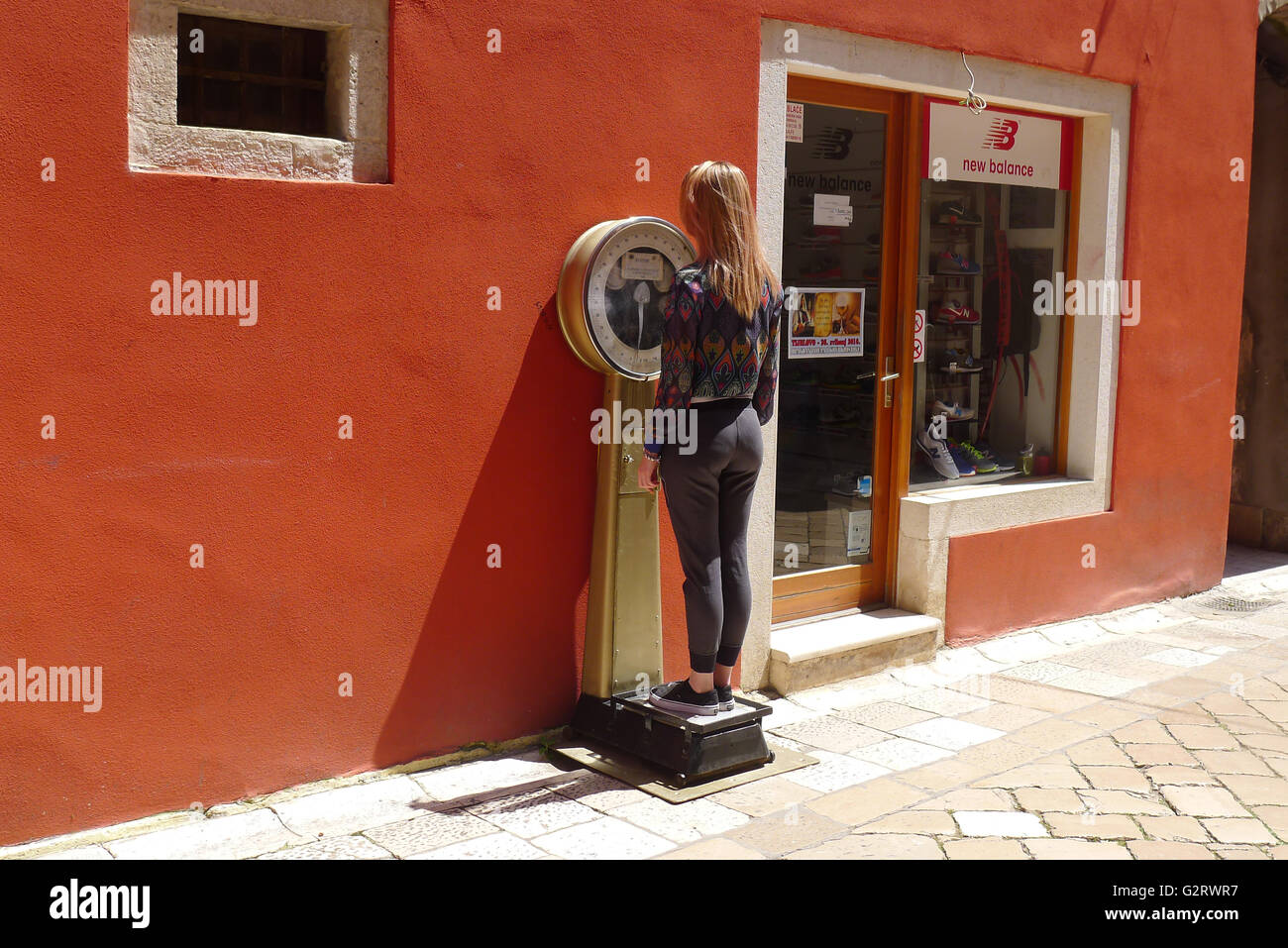 Mädchen mit einem Gewicht von selbst auf einem alten altmodisch mit einem Gewicht von Maschine. Stockfoto