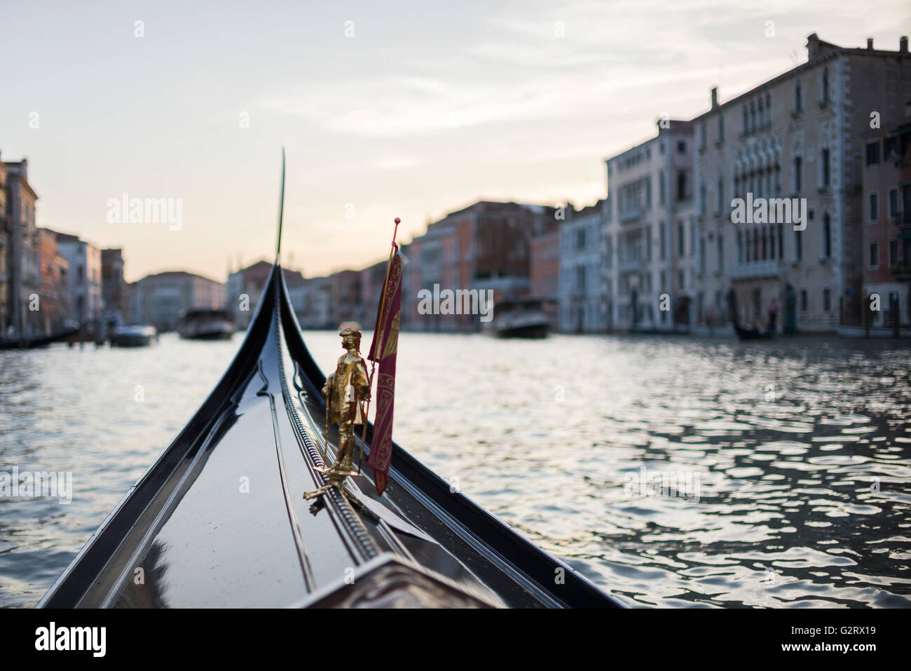 Eine Nahaufnahme der Miniatur Figur vor der Gondel mit der Stadt-Landschaft hinter, Venedig, Italien. Stockfoto