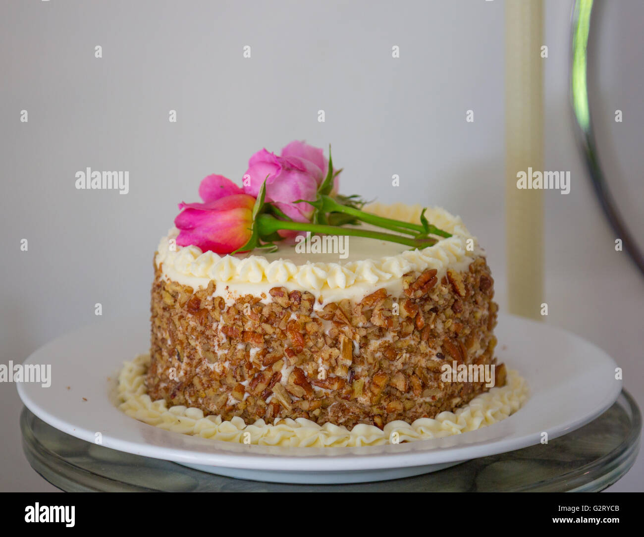 schön gemacht frisch Karottenkuchen mit echten rosa Rosen an der Spitze Stockfoto
