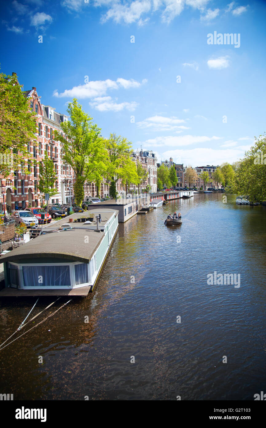 Amsterdam im Sommer. lange alte Häuser hängen über dem Wasser in einer authentischen europäischen Stadt Stockfoto