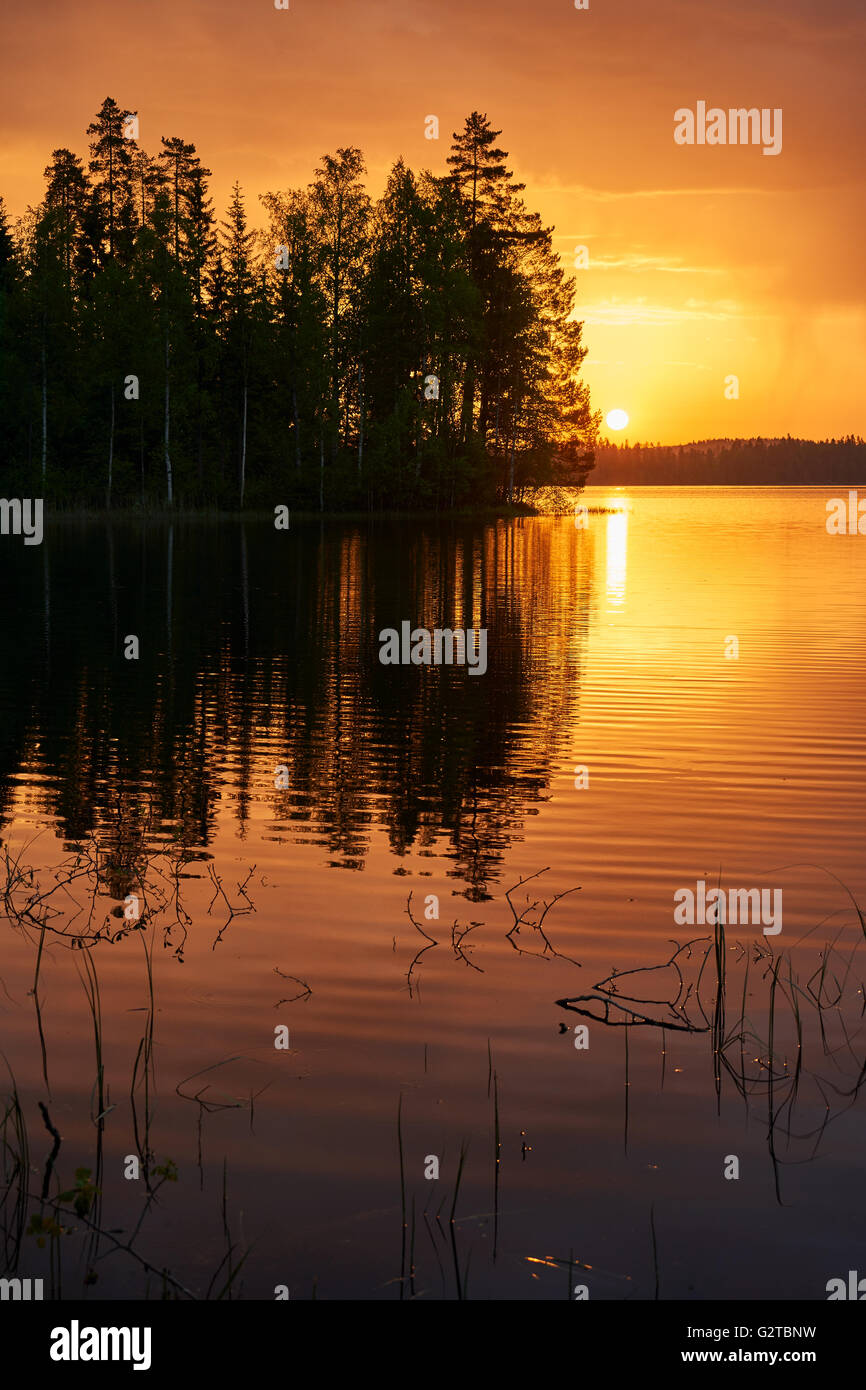 Finnische Landschaft bei Sonnenuntergang mit See, Himmel und Bäume Stockfoto