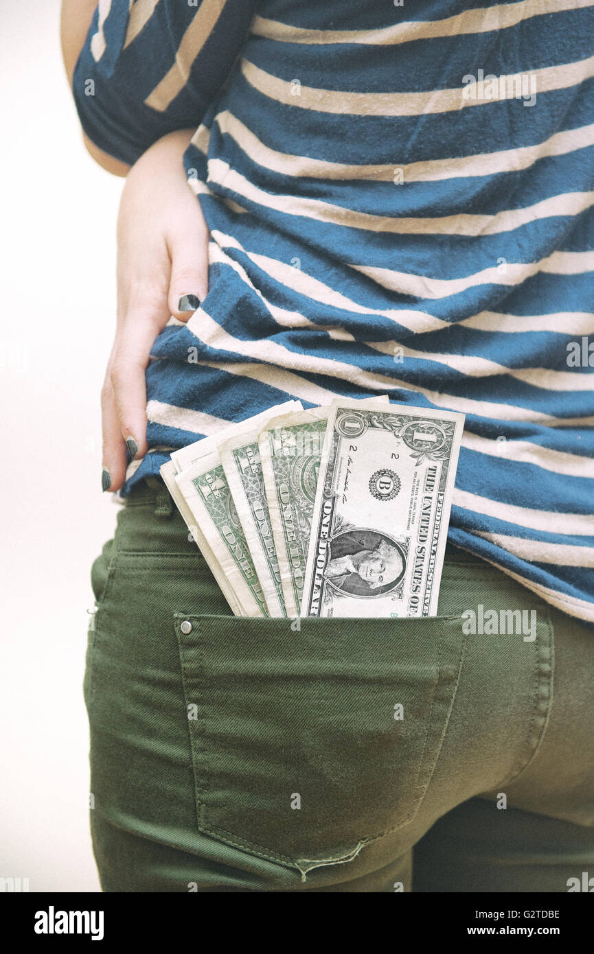 Dollar Geld, die sich aus der Frau Tasche auf weißem Hintergrund Stockfoto