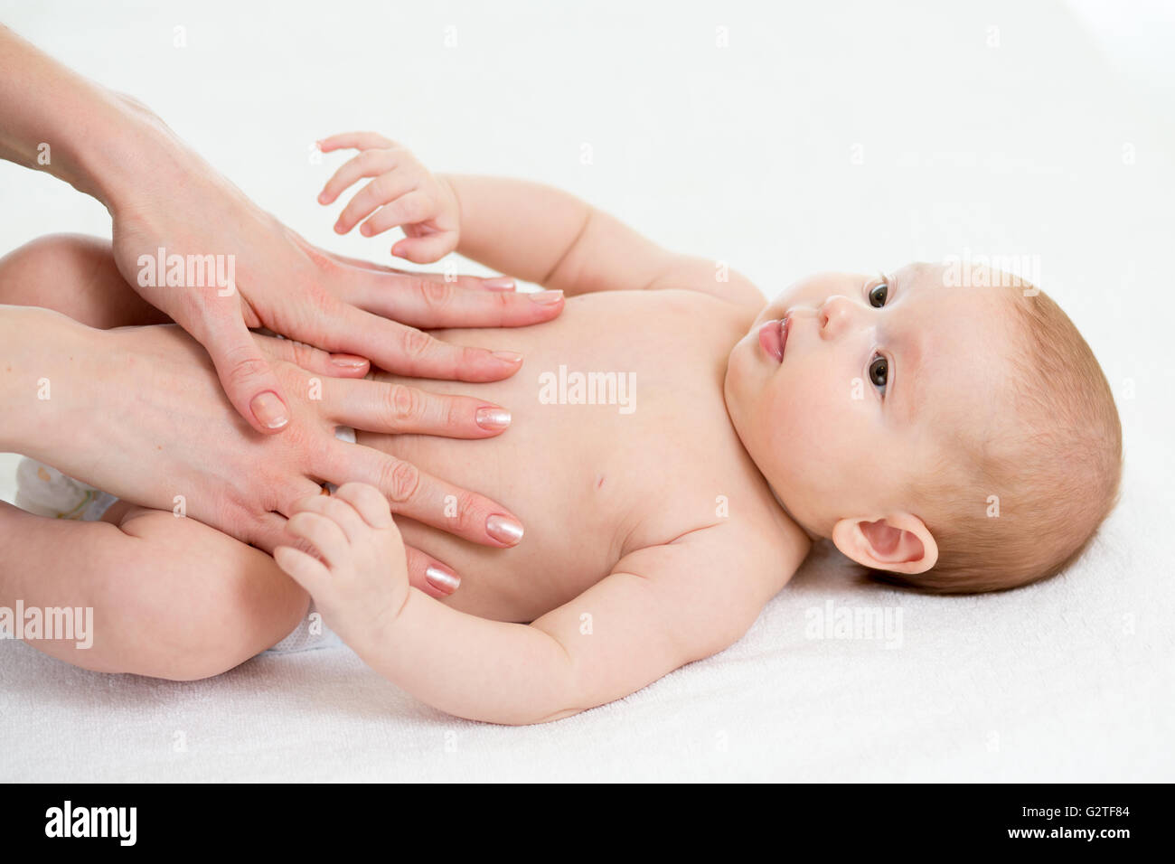 Baby-Massage. Mama Massage Kind Bauch. Behandlung von Koliken Stockfoto