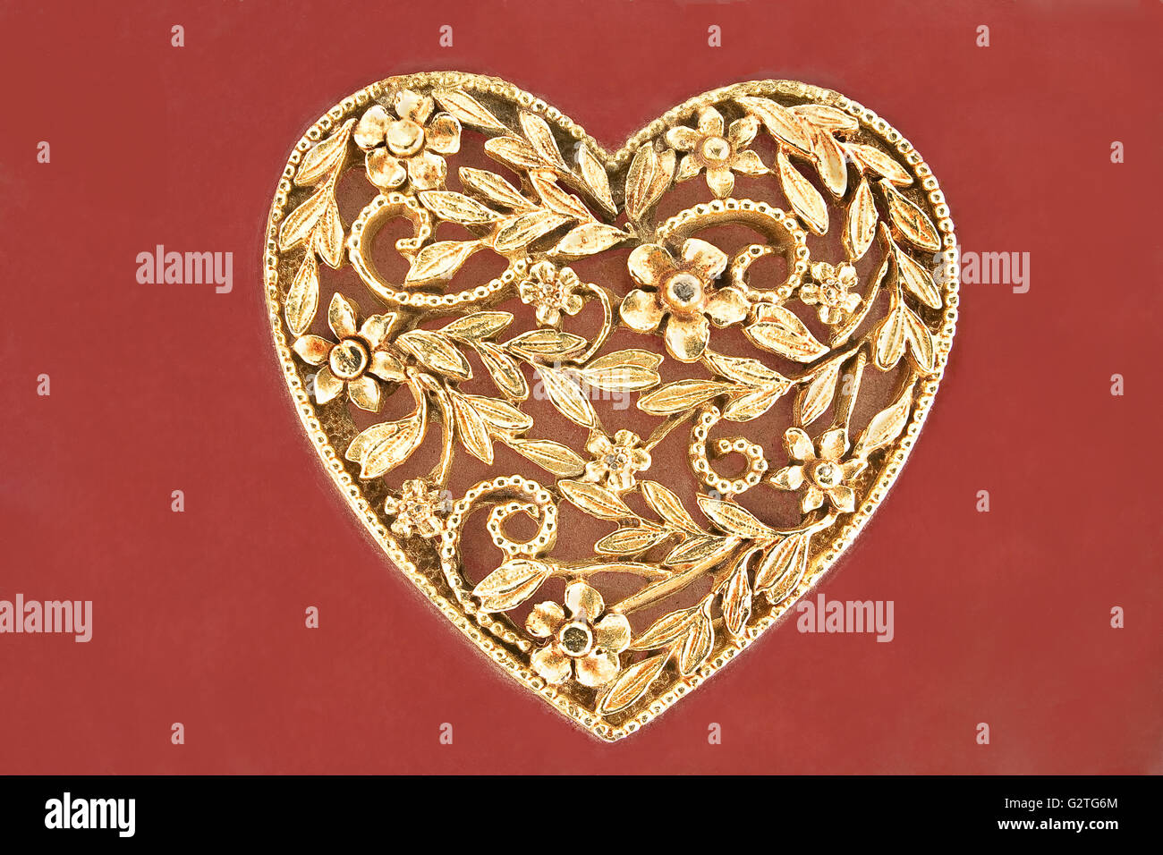 Golden Heart Schmuck auf rotem Grund Stockfoto