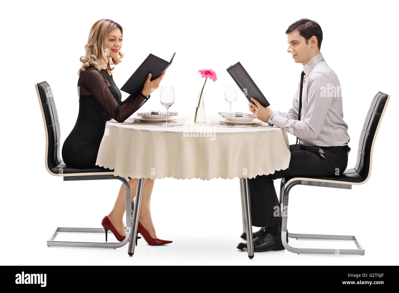 Junges Paar Lesen der Speisekarte und sitzen in einem Restaurant an einem Datum isoliert auf weißem Hintergrund Stockfoto