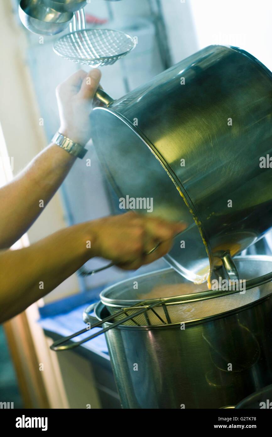 Entleeren einer Pfanne in ein anderes Restaurant Küche Stockfoto