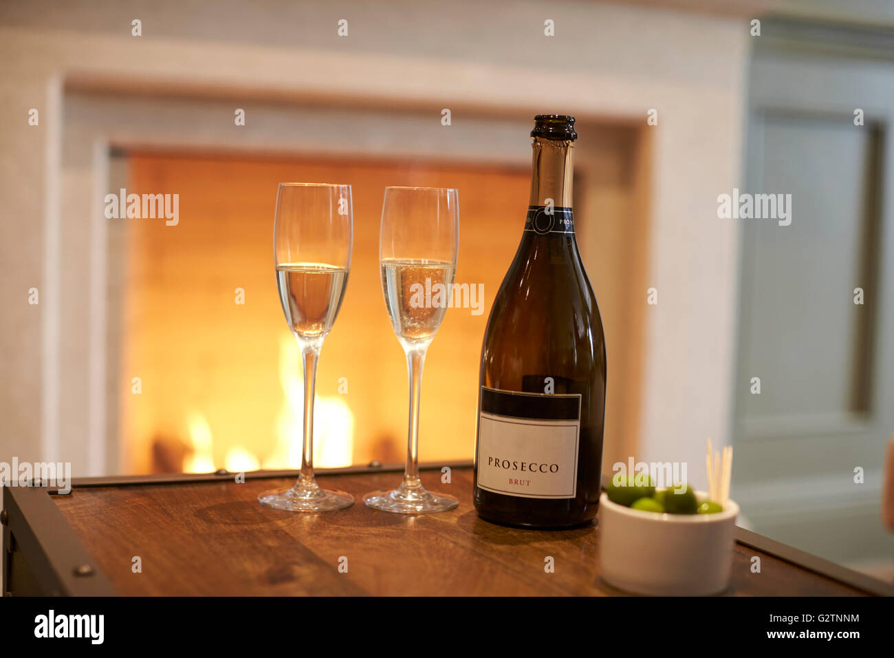 Flasche Champagner mit Brille neben offenen Feuer Stockfoto
