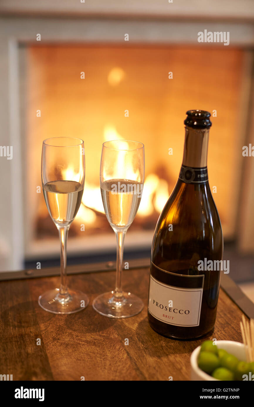 Flasche Champagner mit Brille neben offenen Feuer Stockfoto