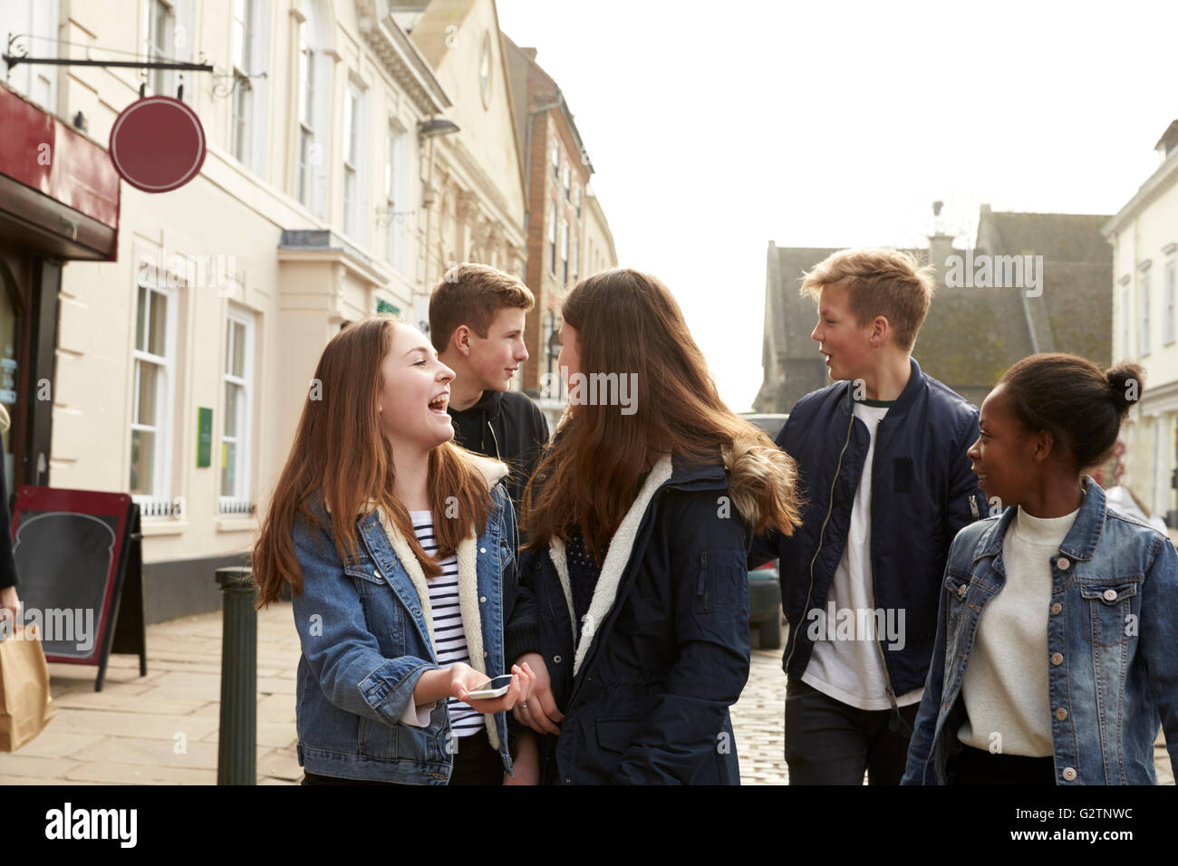 Gruppe von Jugendlichen, die Straße entlang im städtischen Umfeld Stockfoto