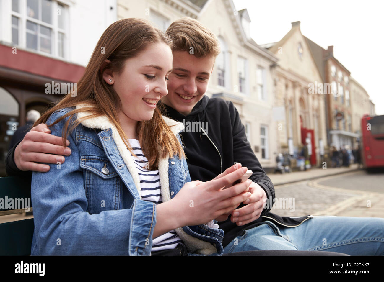 Teenager-Paar mit Handy im städtischen Umfeld Stockfoto