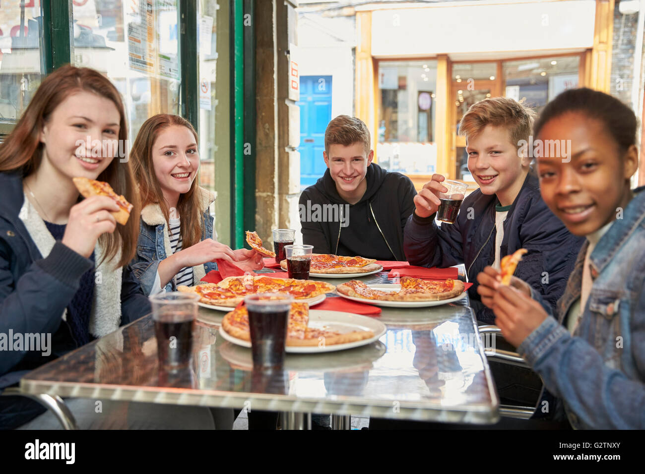 Gruppe von Jugendlichen im Cafe Pizza essen Stockfoto