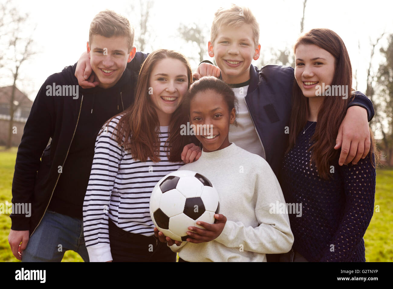 Porträt von Jugendlichen spielen Fußball im Park zusammen Stockfoto