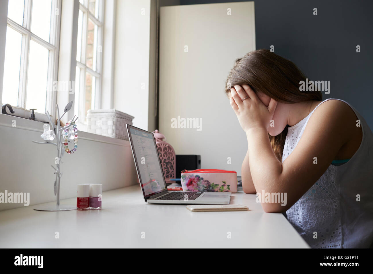 Unglückliche Teenager Opfer von Online-Mobbing im Schlafzimmer Stockfoto