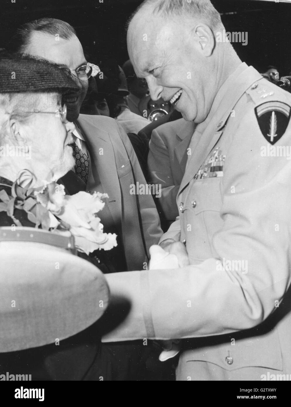 Gen Dwight D. Eisenhower grinst glücklich als er seine Mutter, Frau Ida Eisenhower, erstens grüßt, Schritt vorwärts, wenn Gen Eisenhower aus dem Flugzeug in Kansas City Municipal Airport stieg. Milton Eisenhower, Bruder des Generals, blickt auf. Stockfoto