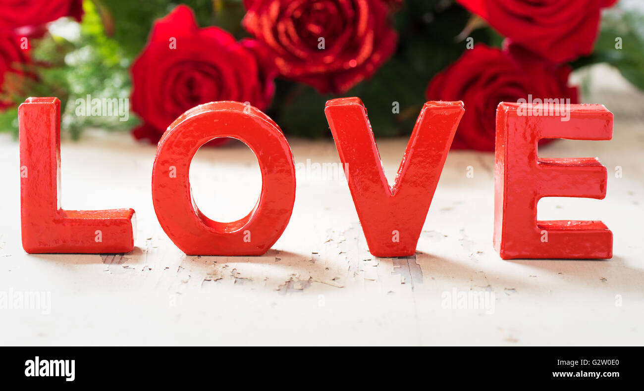 Rote Rosen mit Buchstaben Liebe. Stockfoto