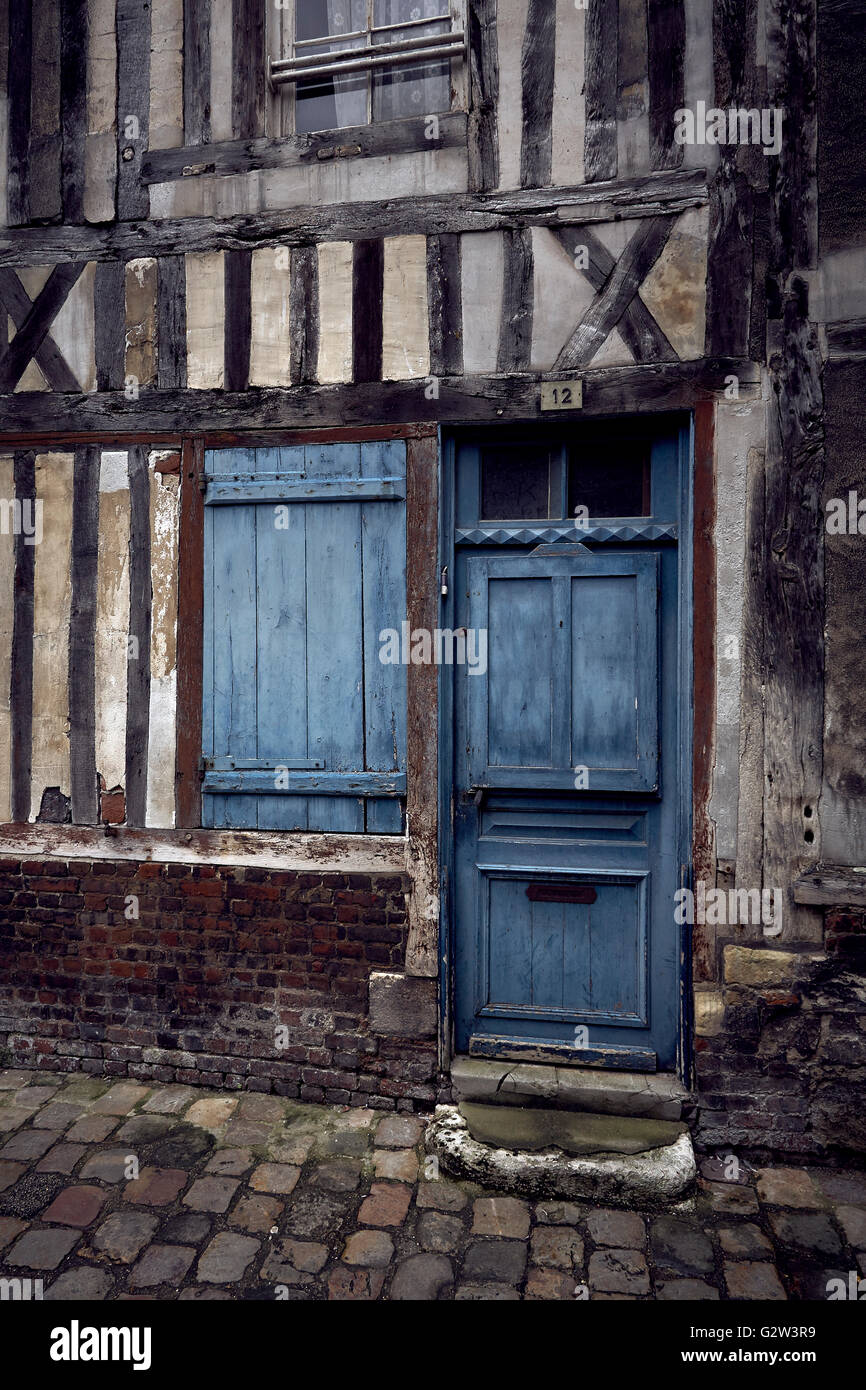 Verwitterte blaue Tür und Verschlusszeit auf Außenseite des alten Fachwerkhaus Gebäude auf gepflasterten Straße in Honfleur, Frankreich Stockfoto